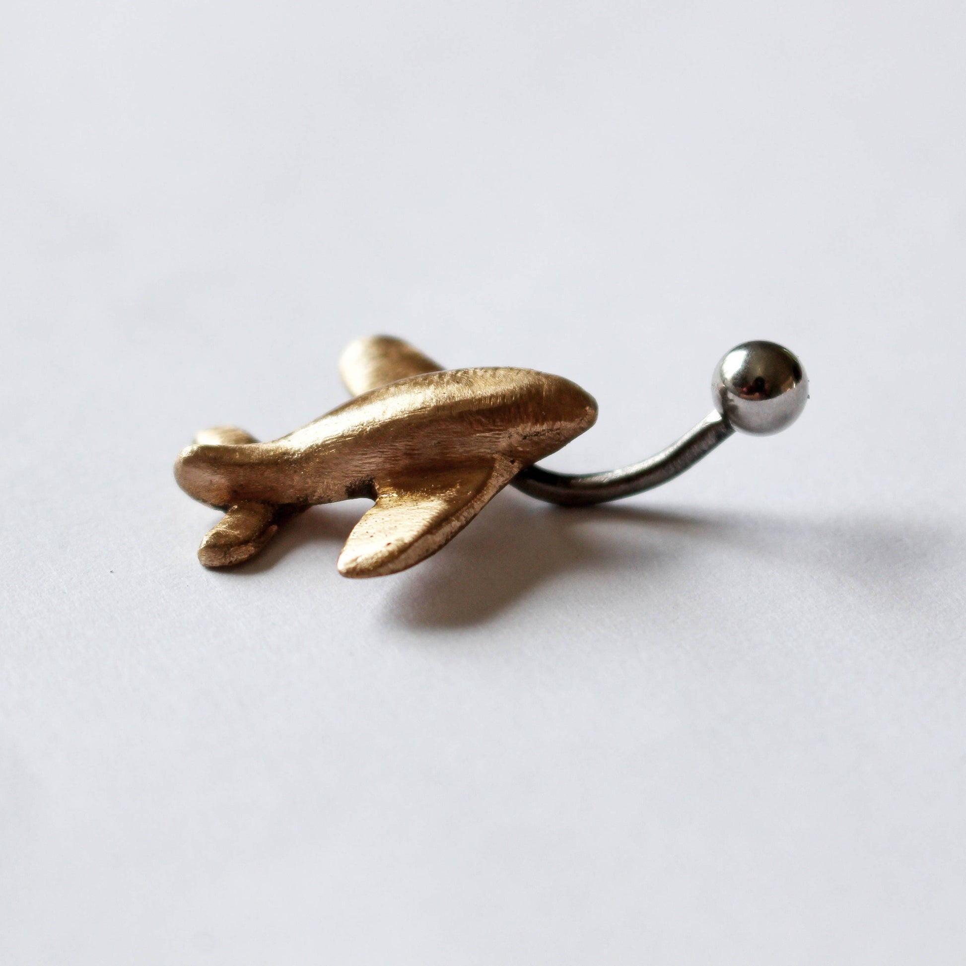 flygplan navelpiercingsmycke, piercingring med ett miniatyr flygplan handgjort i guldig brons
