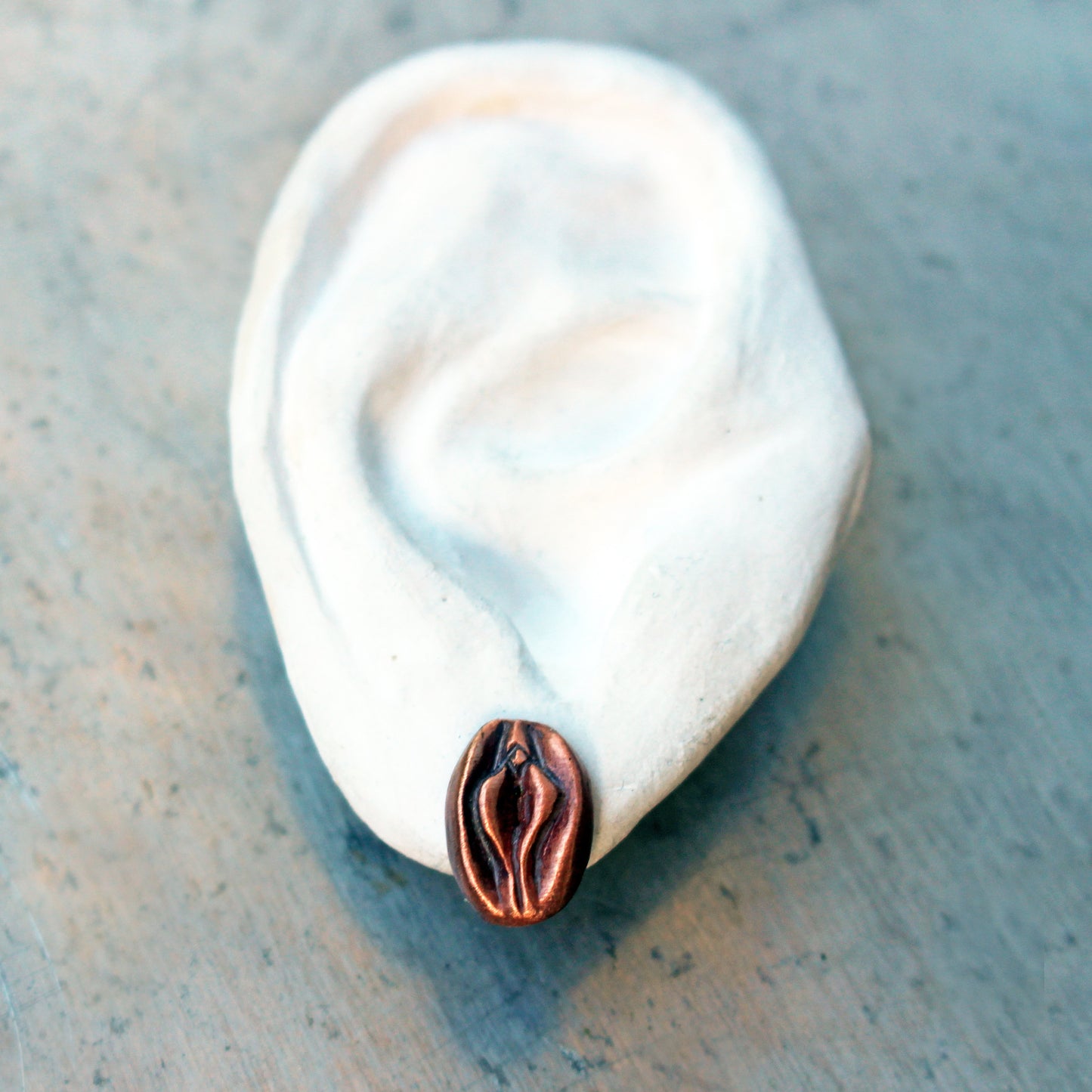 vagina fittöhängen skulpterade i rosa koppar med titankrokar