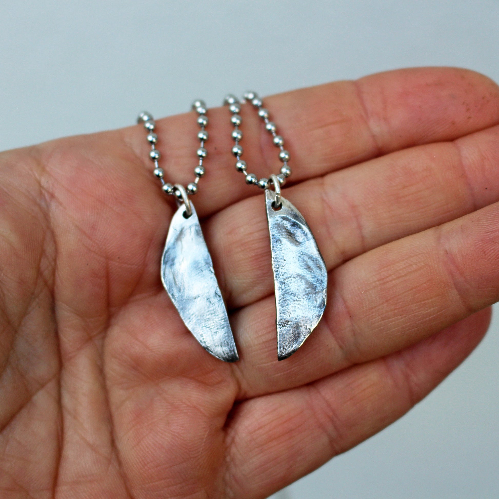 baksida, halsband i silver med en fitta som är delad på mitten, halsband att dela med sin partner