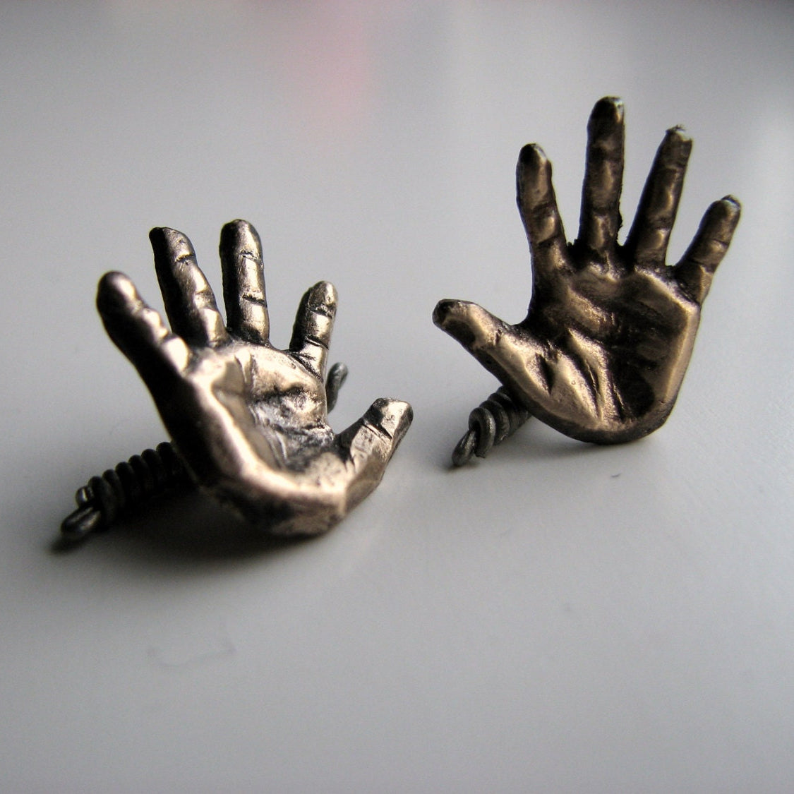 Bronze hand-shaped cufflinks on a light gray background