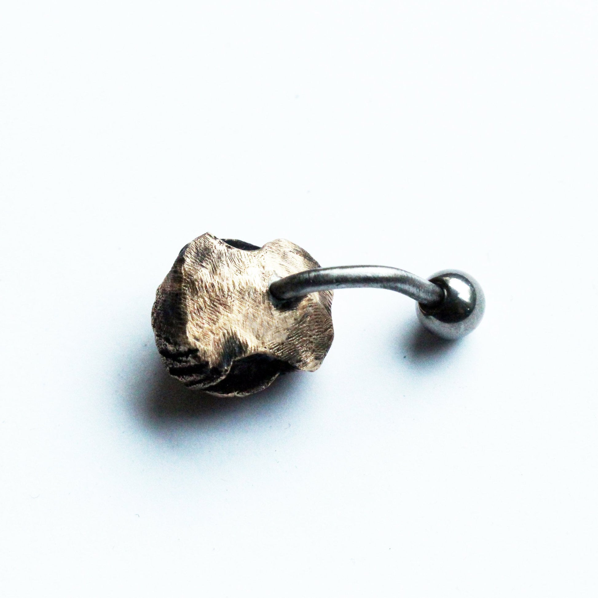 baksida, titan navelpiercingsmycke med skulpterade monstergaddar huggtänder i brons