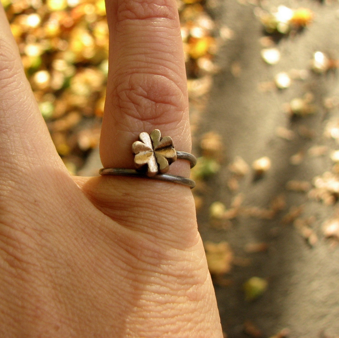 justerbar fingerring med en fyrklöver, i brons och rostfritt stål