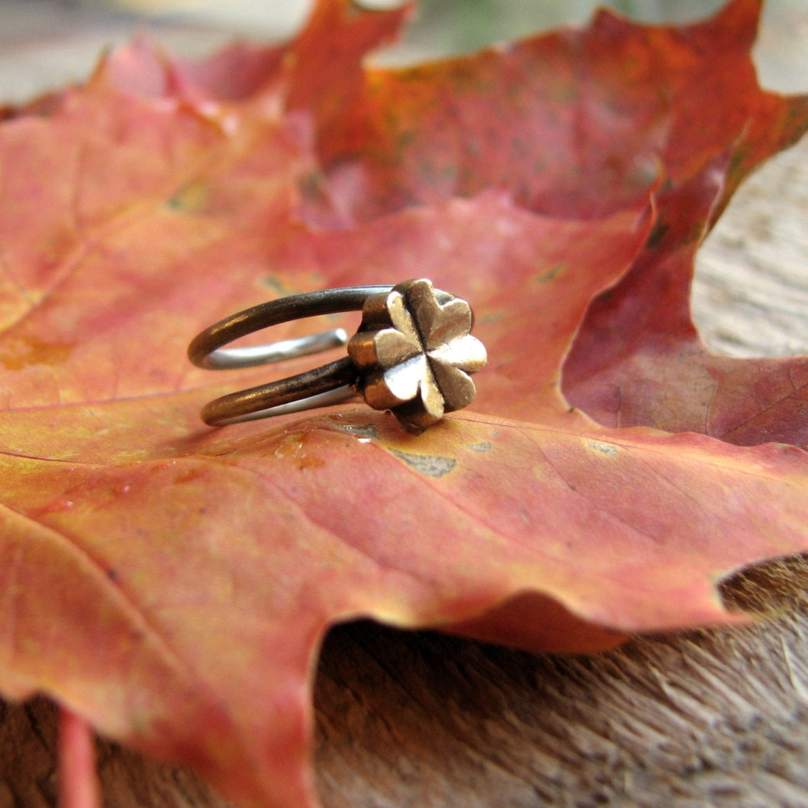 justerbar fingerring med en fyrklöver, i brons och rostfritt stål