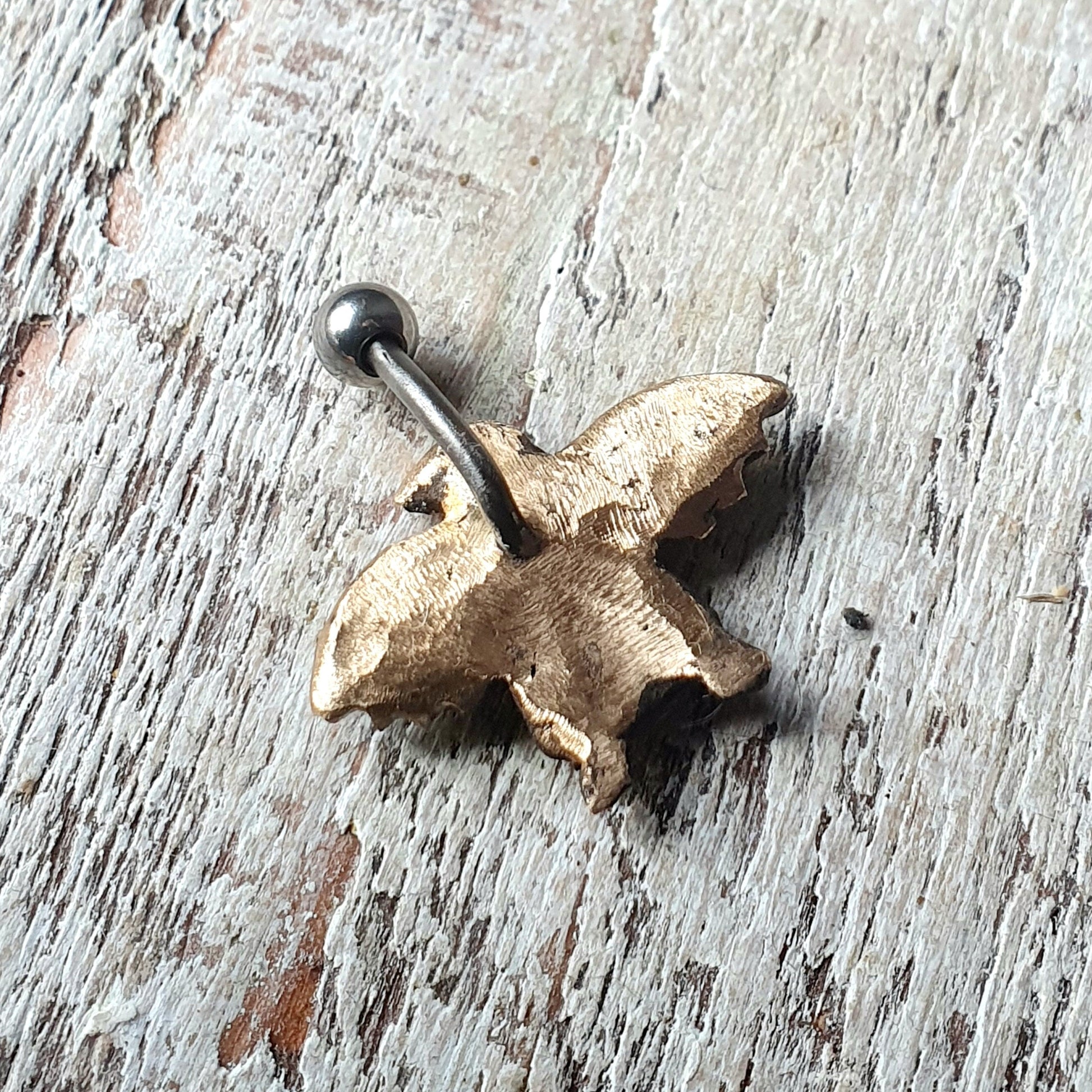 baksida navel piercing smycke med en handgjord brons pingving med lösvingar