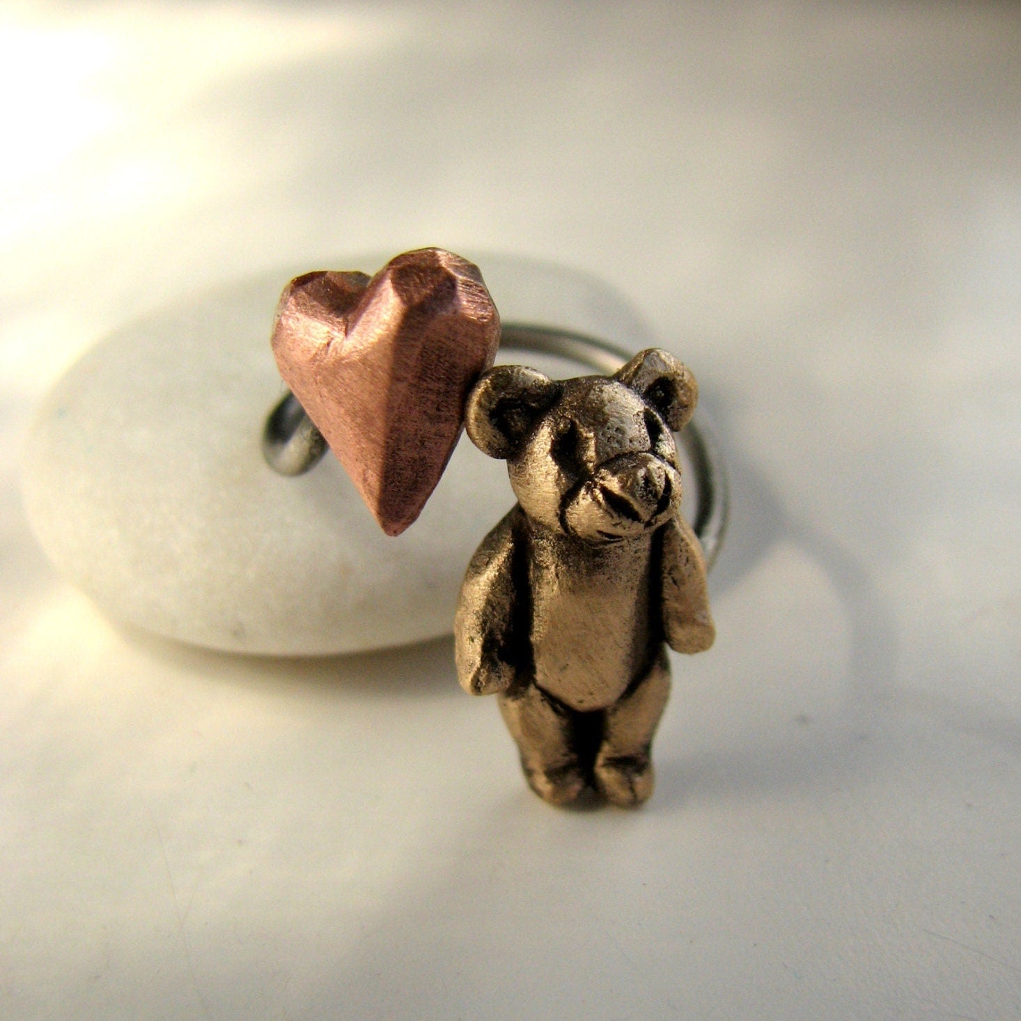 teddybjörn finger ring med en miniatyr nalle och ett hjärta i rosa koppar
