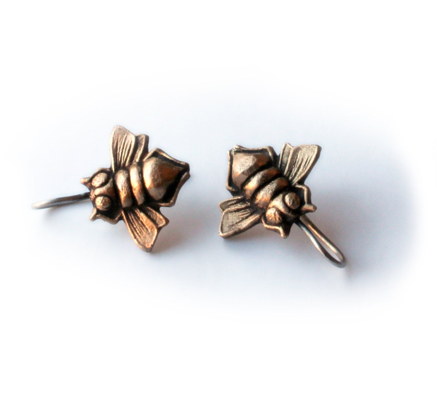 A pair of bronze-colored titanium earrings shaped like bees with dangling details.