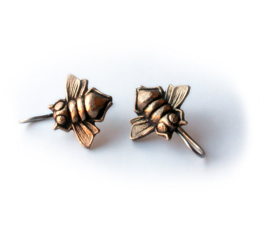 A pair of bronze-colored titanium earrings shaped like bees with dangling details.