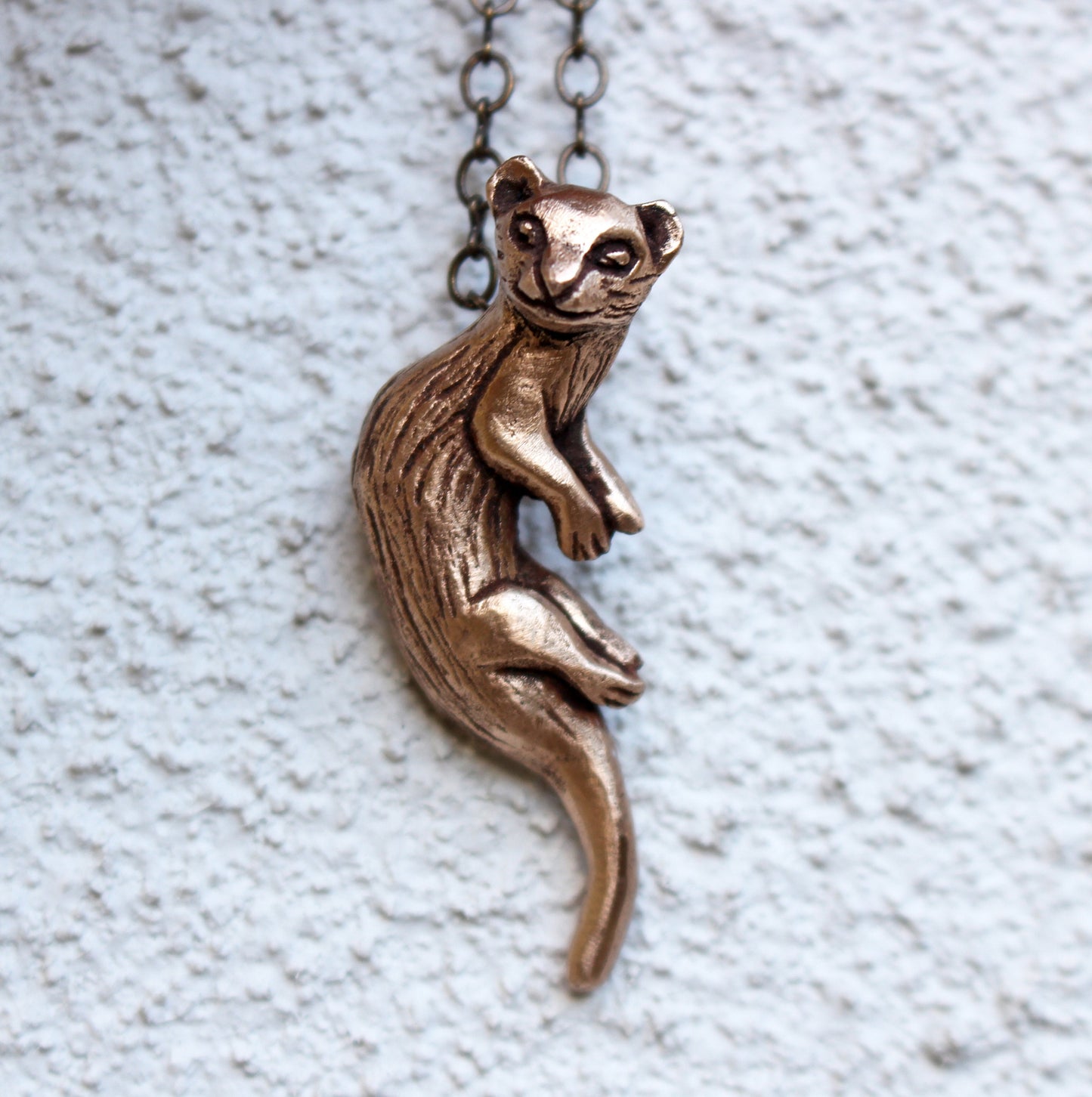 iller halsband skulpterat i brons på en vit bakgrund