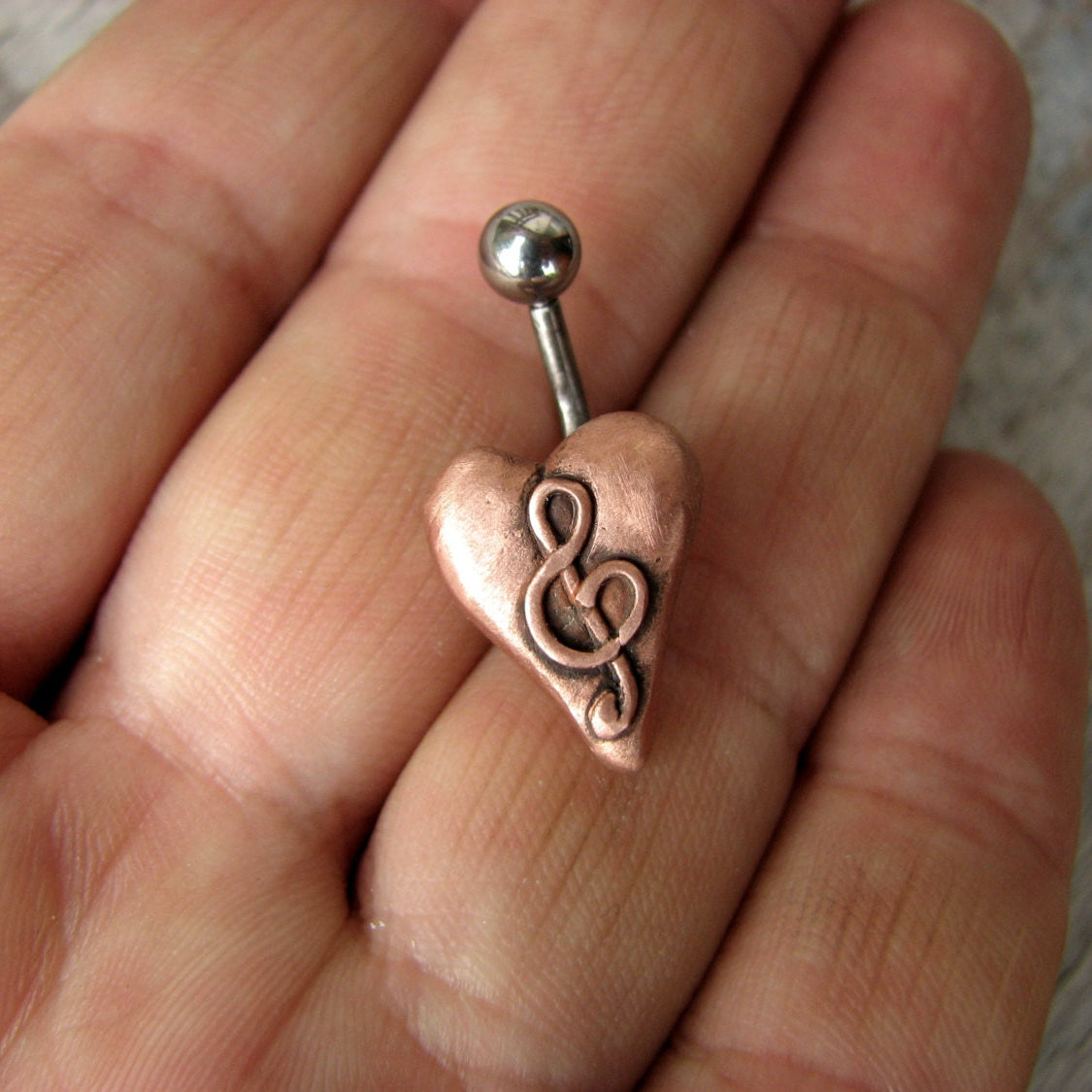 Jag älskar musik. Navelpiercing smycke med ett rosa hjärta med en g klav på