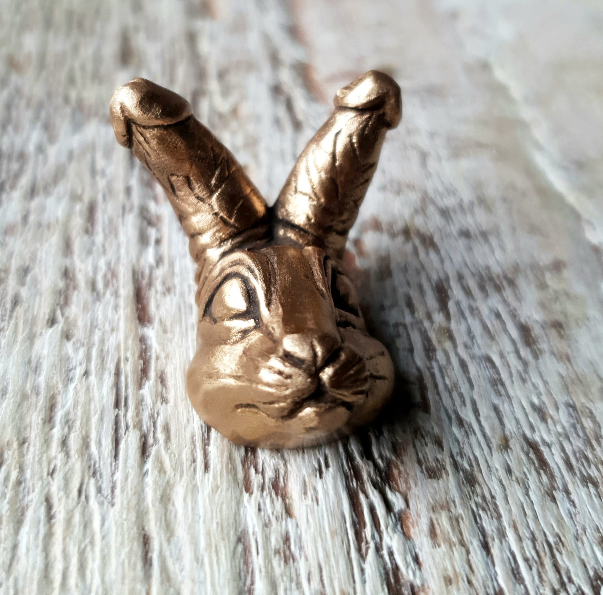 miniatyr brons skulptur med en kanin med kukar som öron, som halsband 