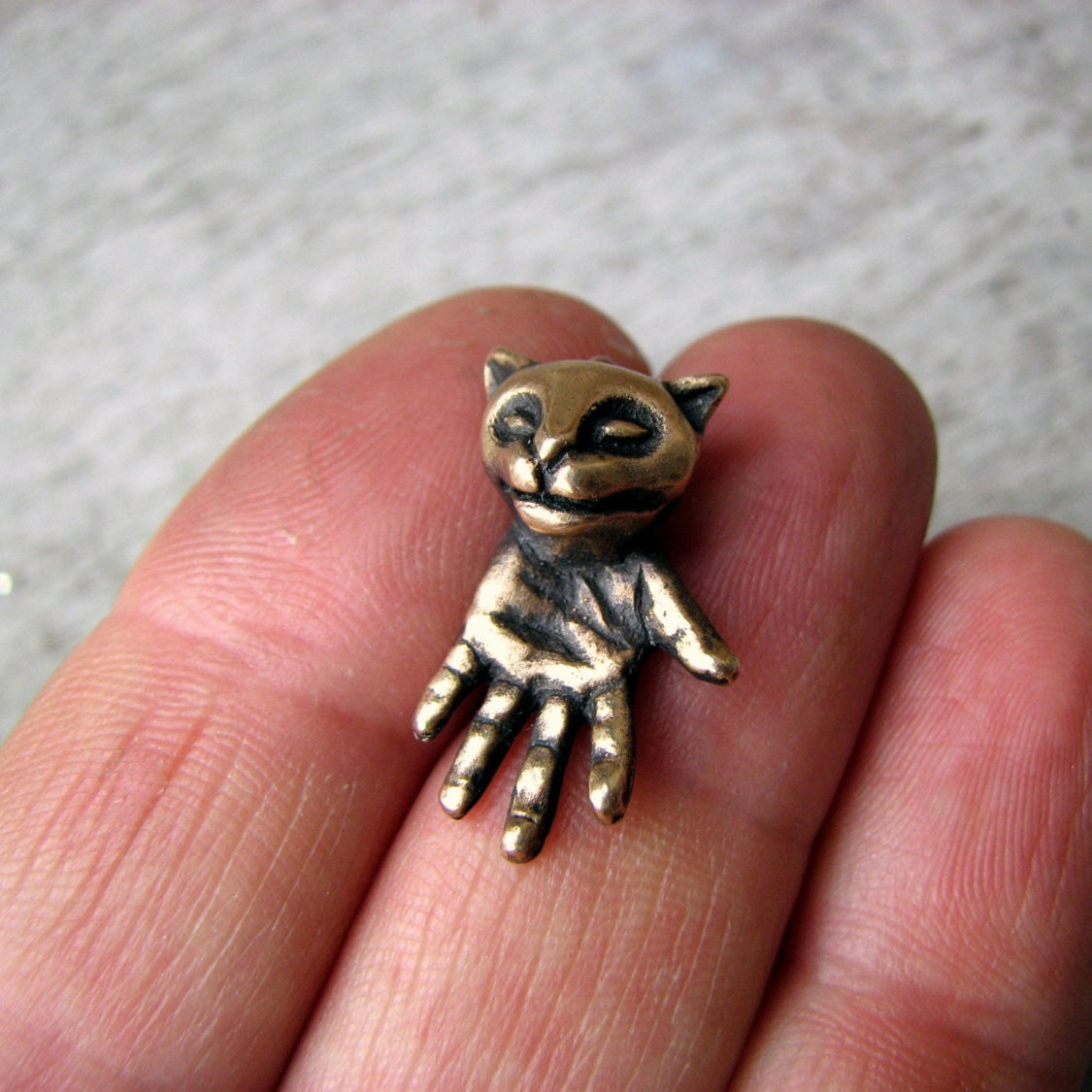 surrealistiskt katthalsband figyr med ett katthuvud och en hand som kropp