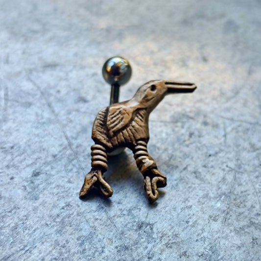 Bronze and titanium kiwi bird  belly button ring on a gray surface