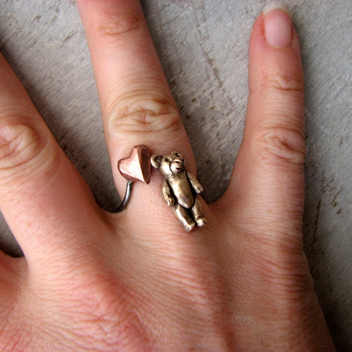 teddybjörn finger ring med en miniatyr nalle och ett hjärta i rosa koppar