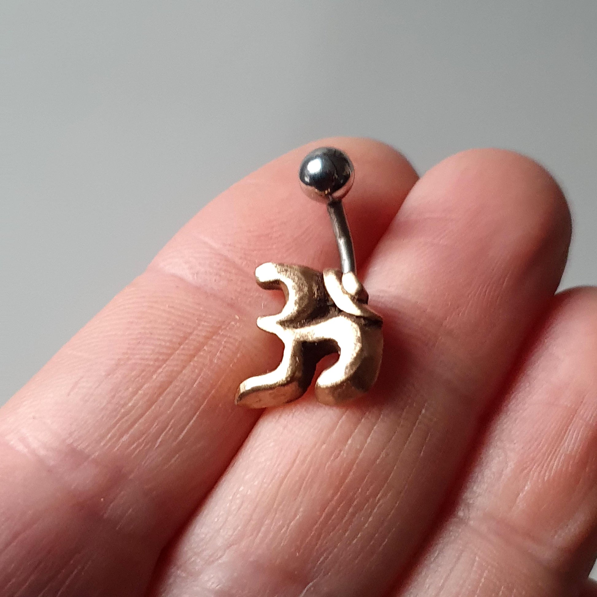 Navel piercing smycke med yoga symbolen ohm skulpterad i brons med stav i titan eller kirurgiskt stål