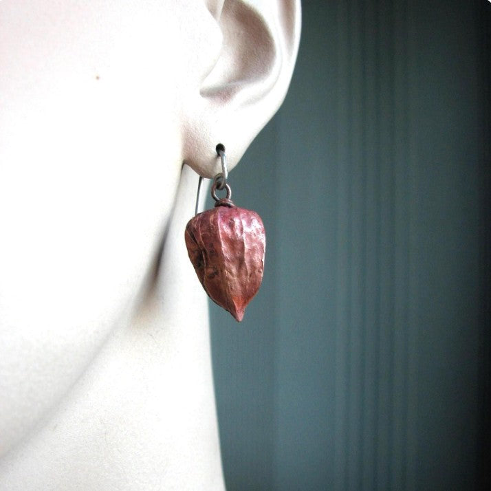 physalis örhänge i koppar och titankrok på modell