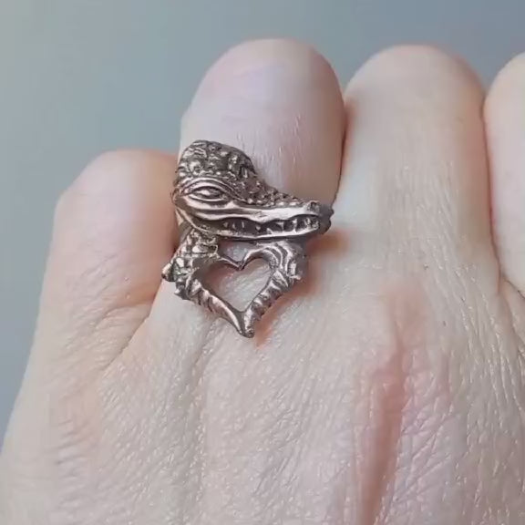 alligator making heart sign with it´s claws sculpted in bronze made as a finger ring