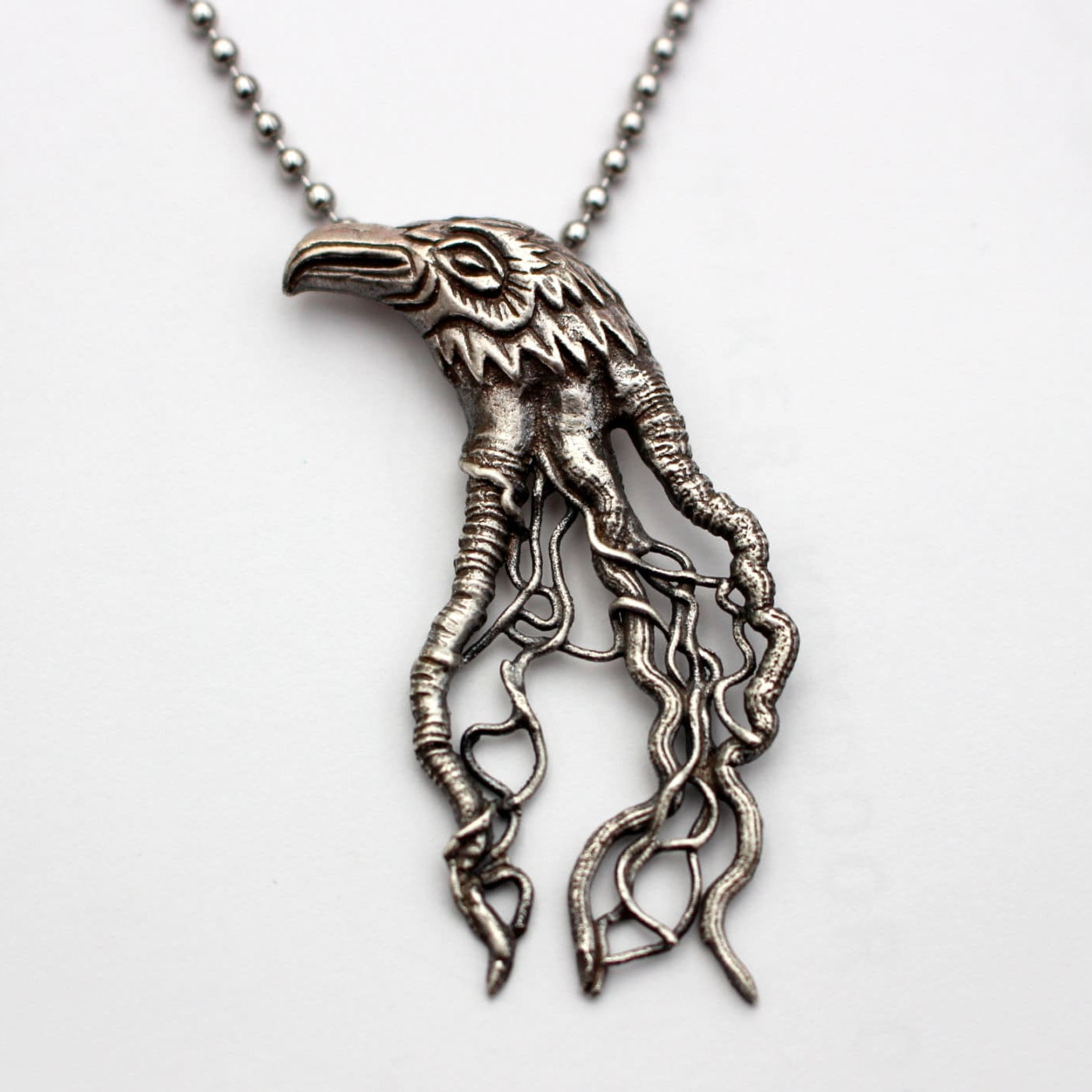 sterling silver bird head pendants with intricate filigree designs, roots, veins flowing from the head