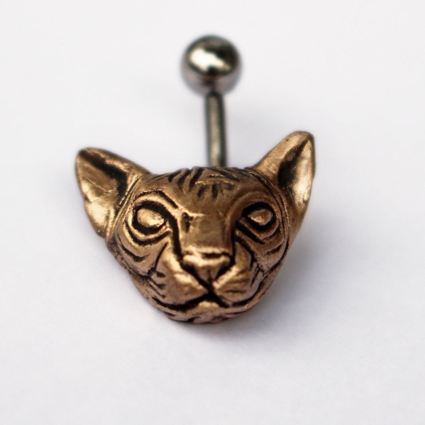 belly button rpiercing with a bronze cat head attached to a curved barbell.