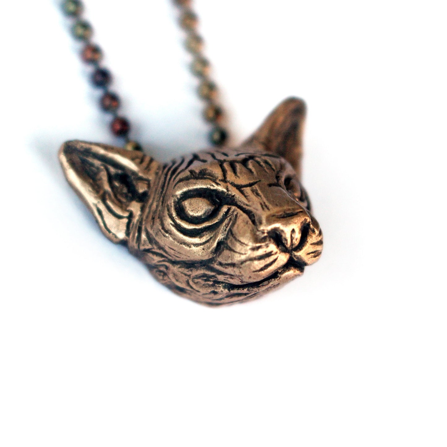 a sculpted bronze sphynx cat head necklace 