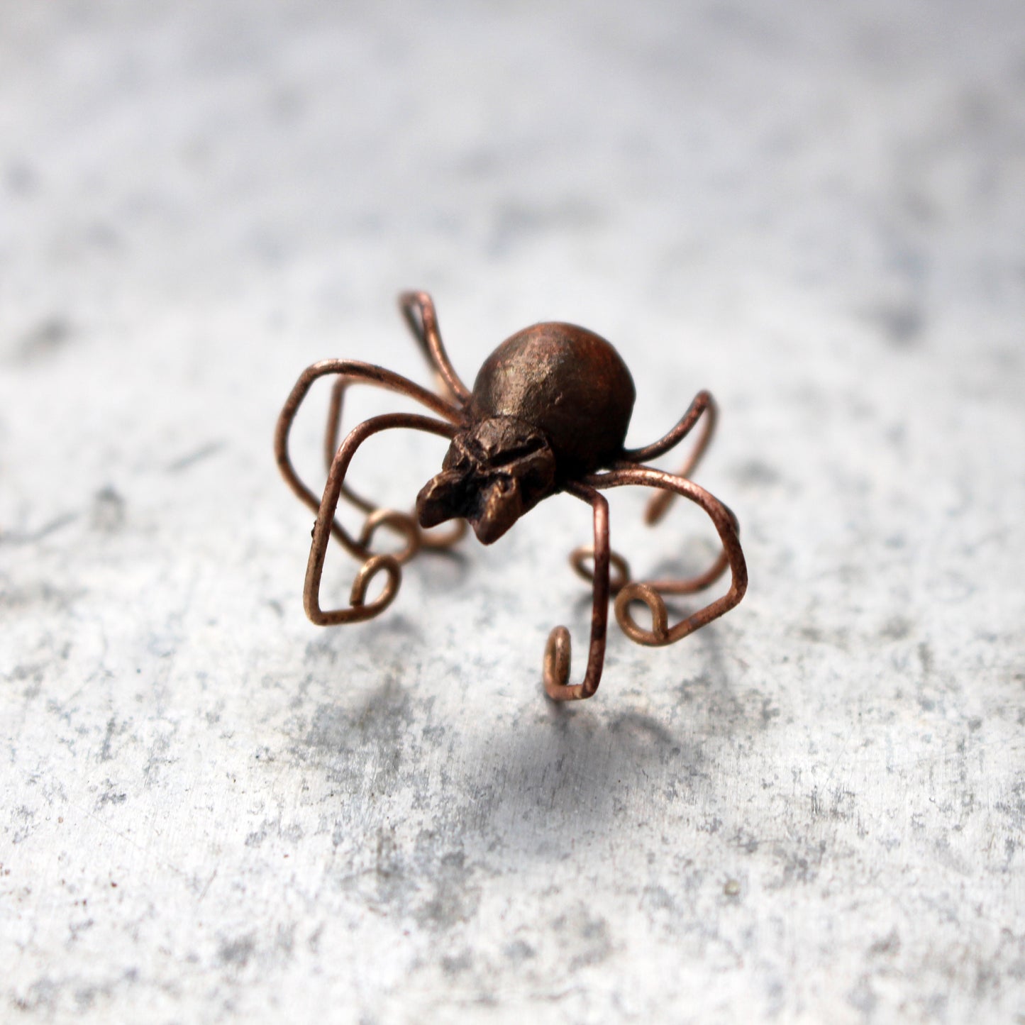 spindel ear cuff på en ljus yta