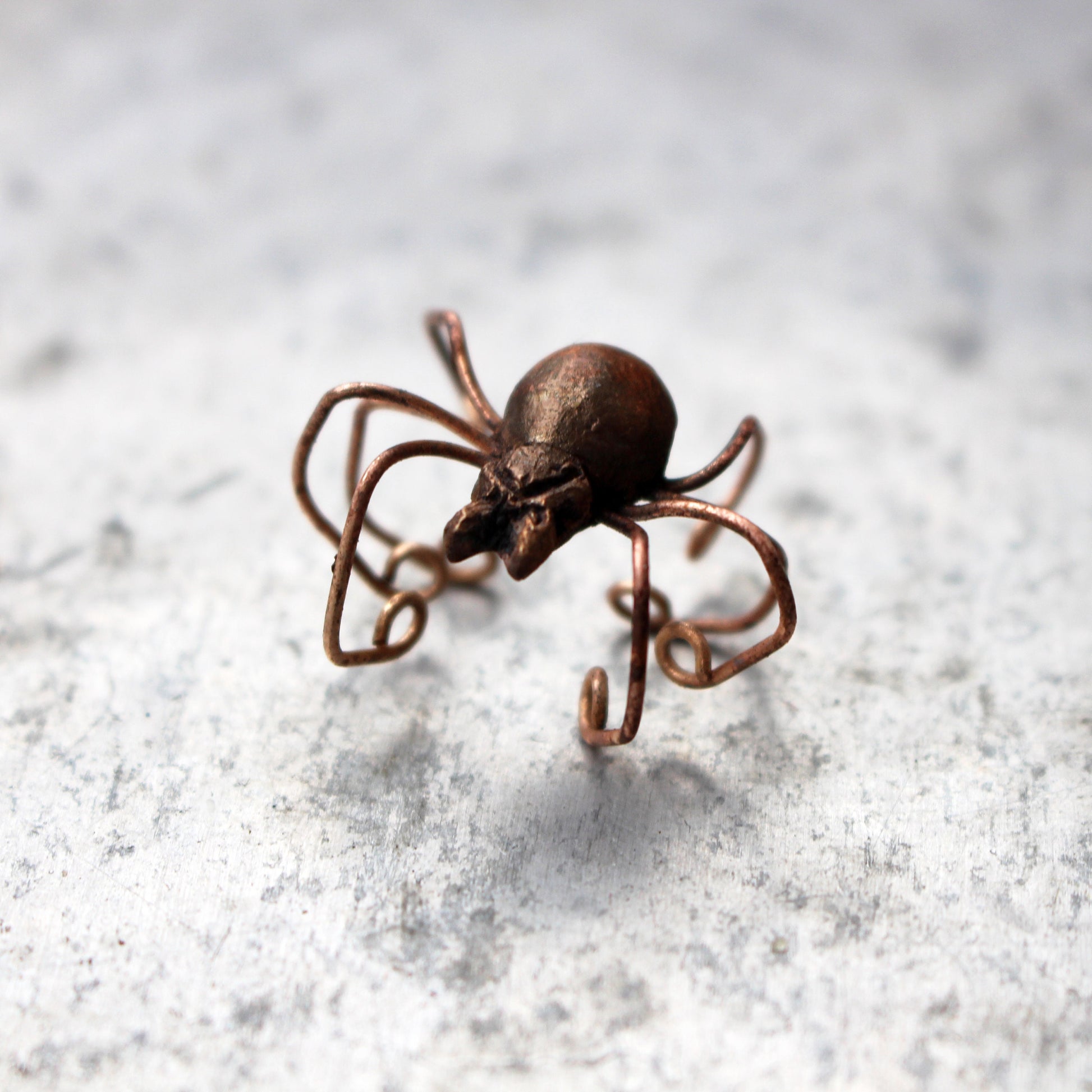 spindel ear cuff på en ljus yta