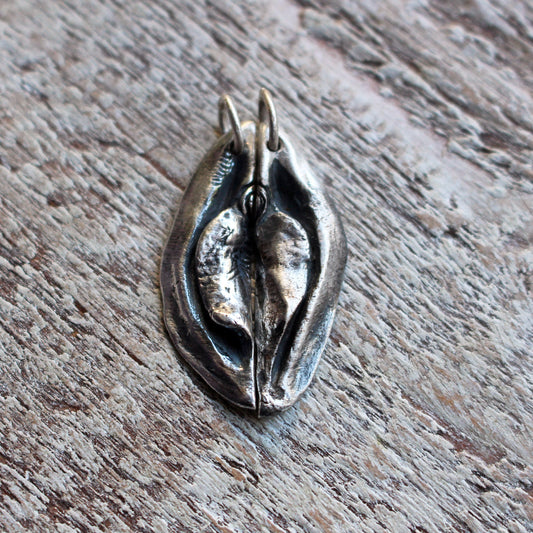 an artistic necklace pendant, designed as a split heart vagina vulva, to share with a lover