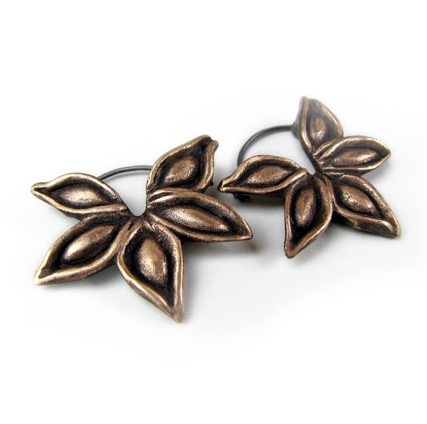 A pair of bronze sculptural hoop earrings with a stylized star anise seed pod design, complete with earwires of ttanium