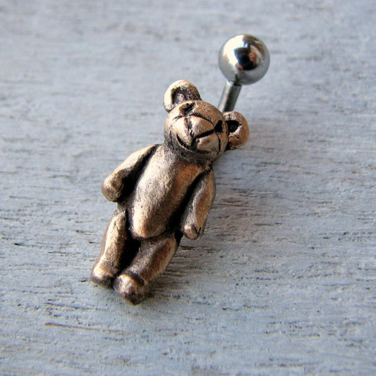 piercingsmycke i titan eller kirurgiskt stål med en handgjord teddybjörn i brons