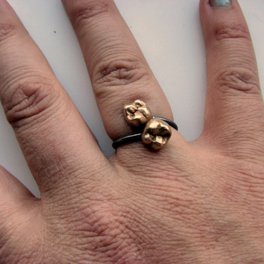 an adjustable ring with two bronze teeth