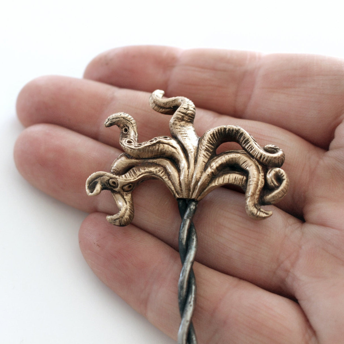 hårsticka med bläckfisk tentakler skulpterad i brons