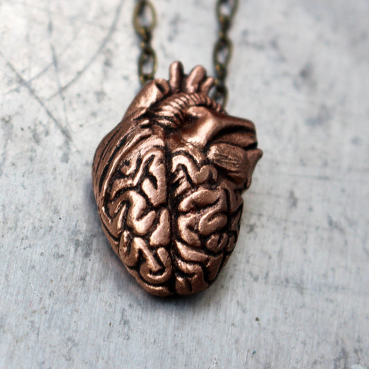 pendant with a mix of anatomical heart and brain sculpted in metal