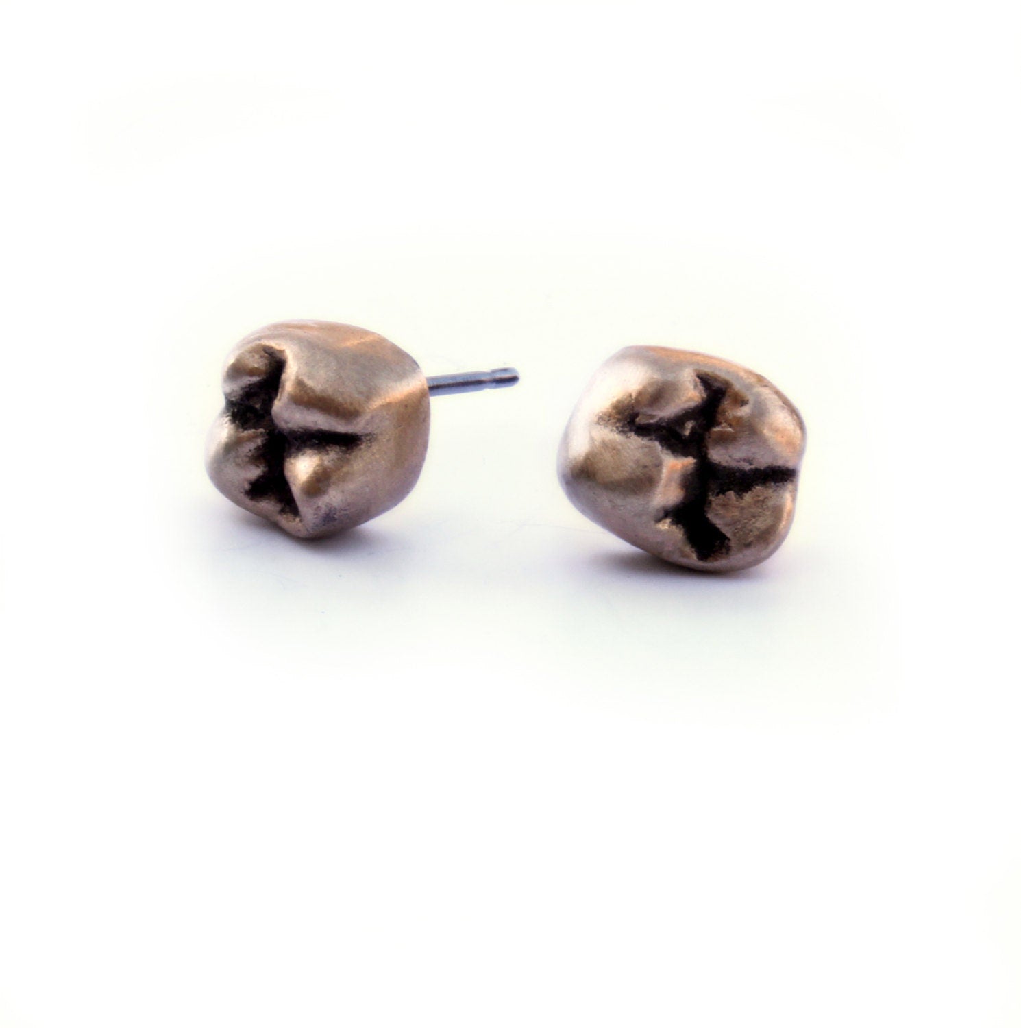 A pair of golde bronze tooth-shaped stud earrings with titanium earwires