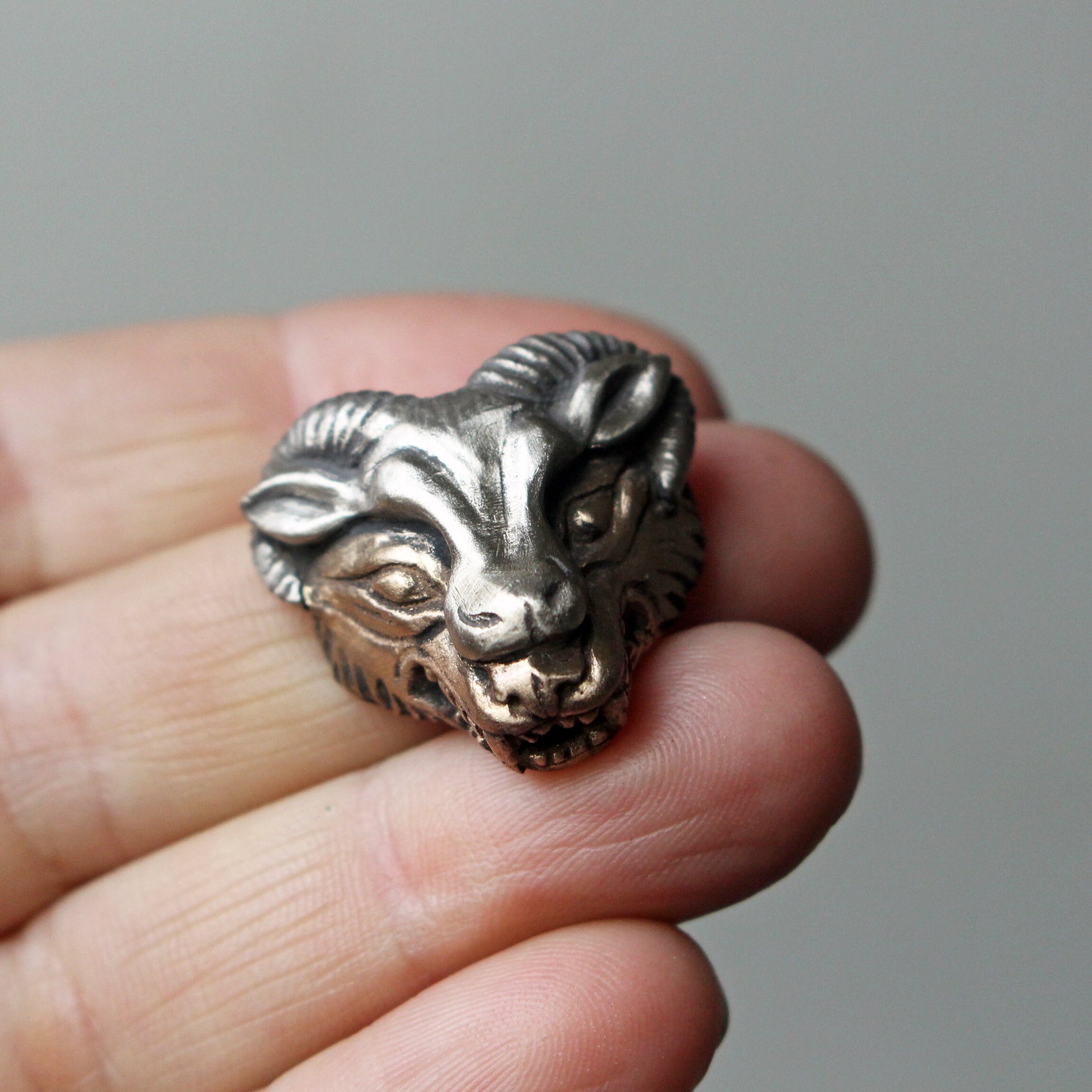 Ulv i fårakläder halsband, varghuvudet är skulpterat i brons och bär en får mask skulpterad i vit brons