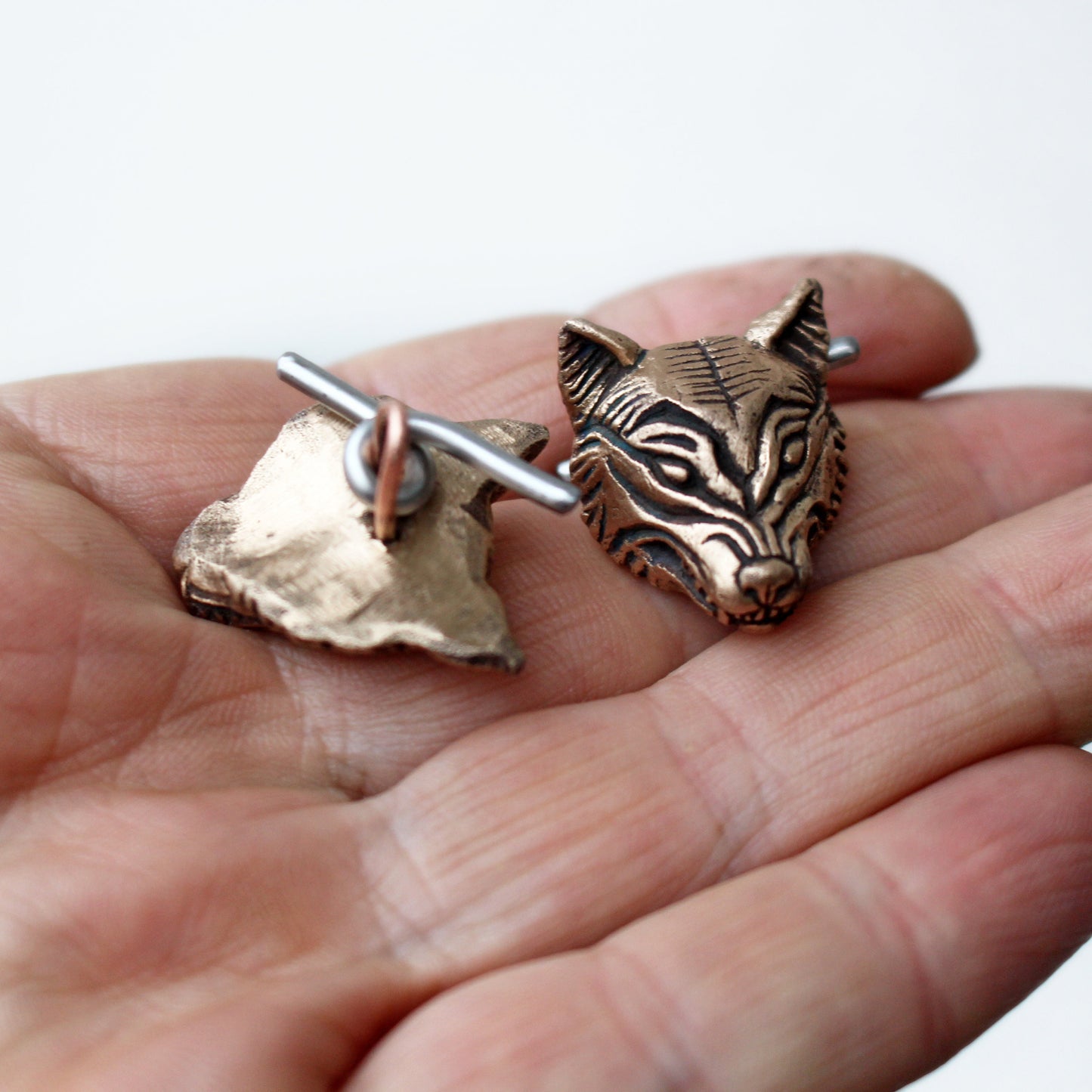 vargmanschettknappar i brons och rostfritt stål