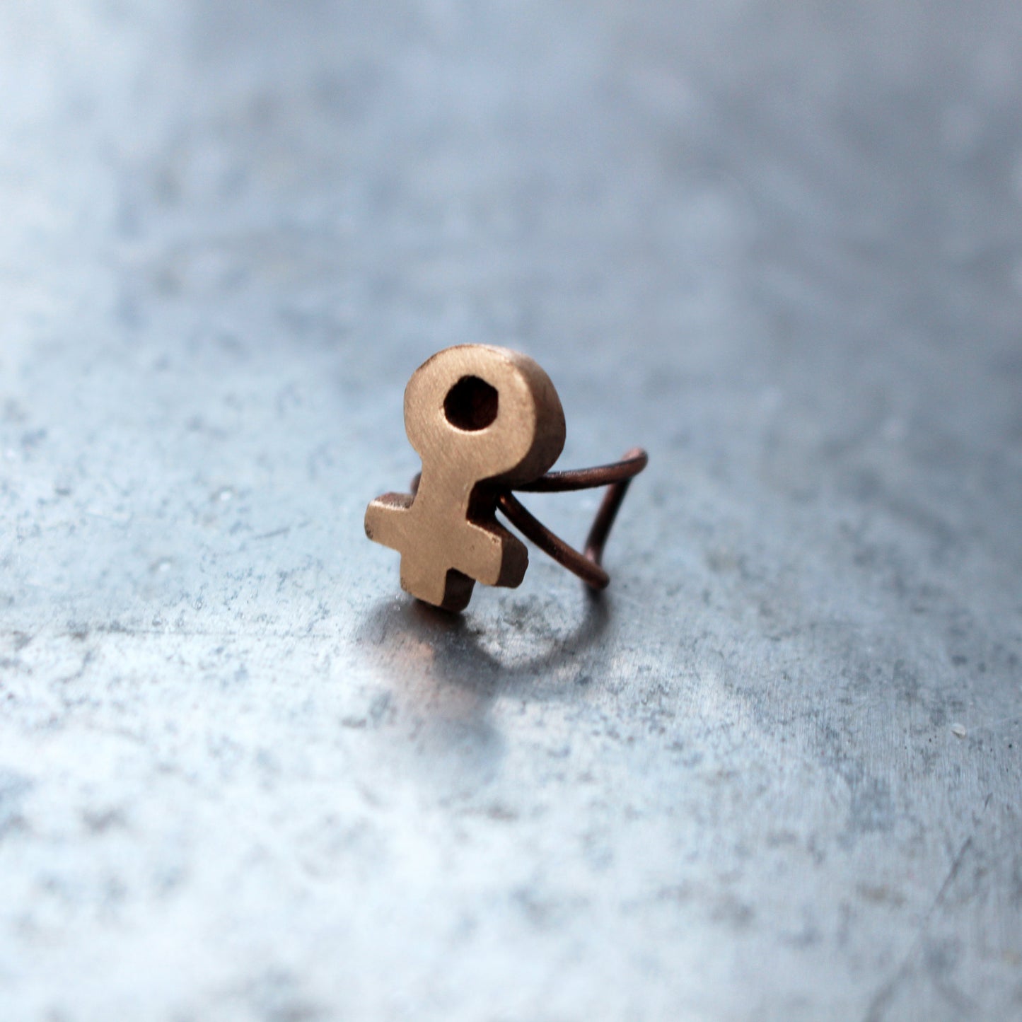 örhänge earcuff med feministsymbol skulpterad i brons