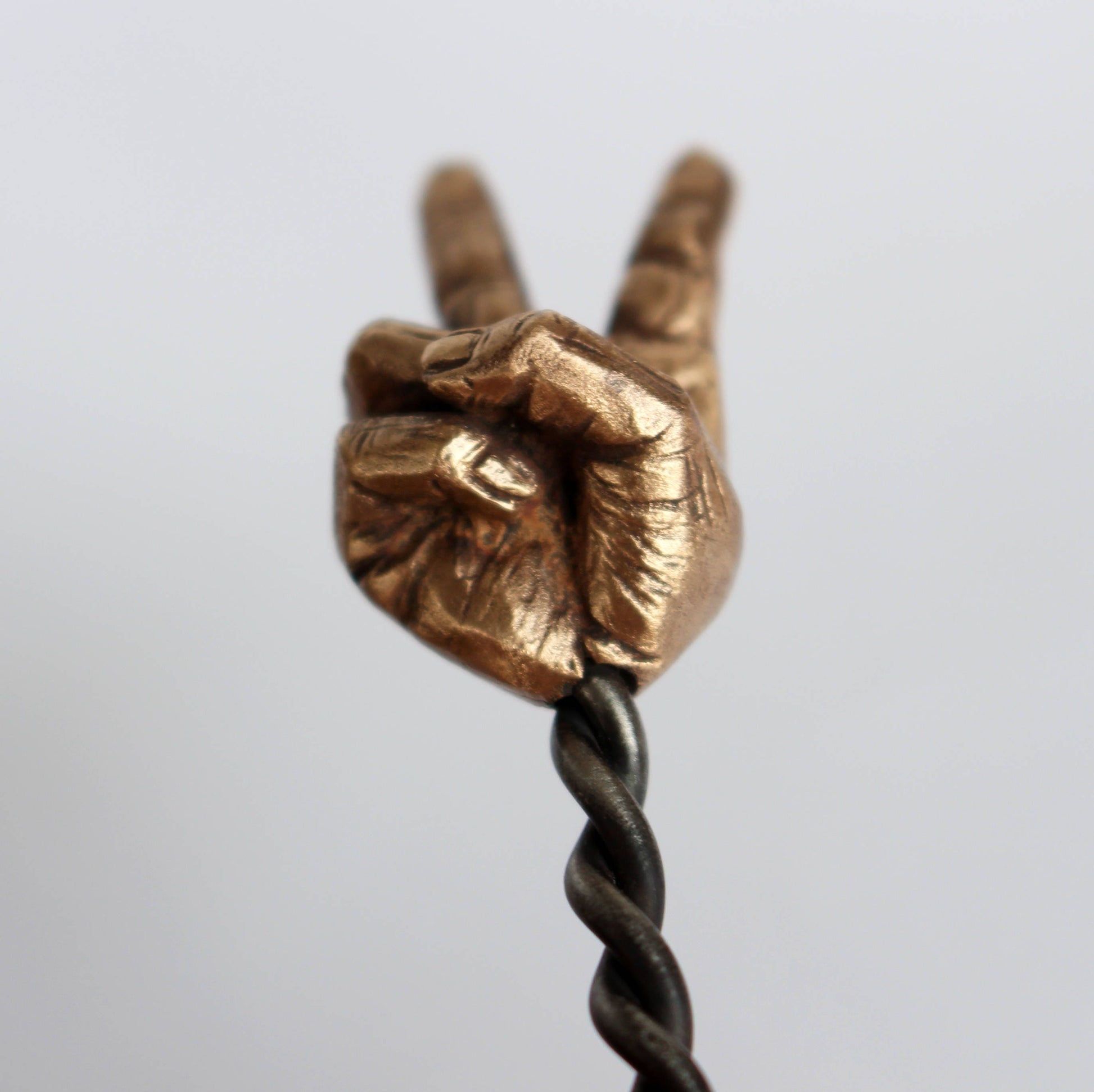 hair jewelry with a sculpted miniature hand making a peace sign with a forged  stainless steel stick