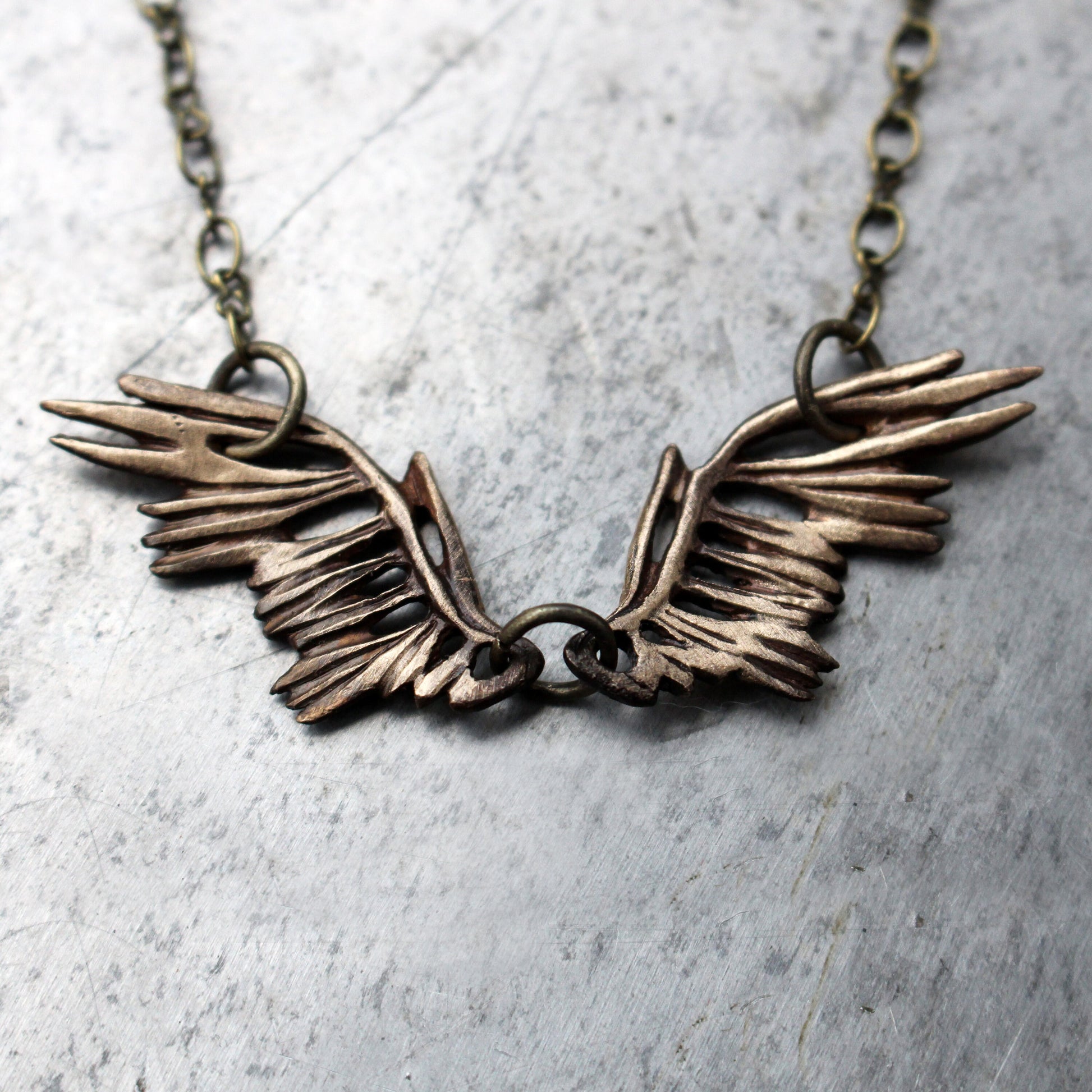 halsband med brons fågelvingar