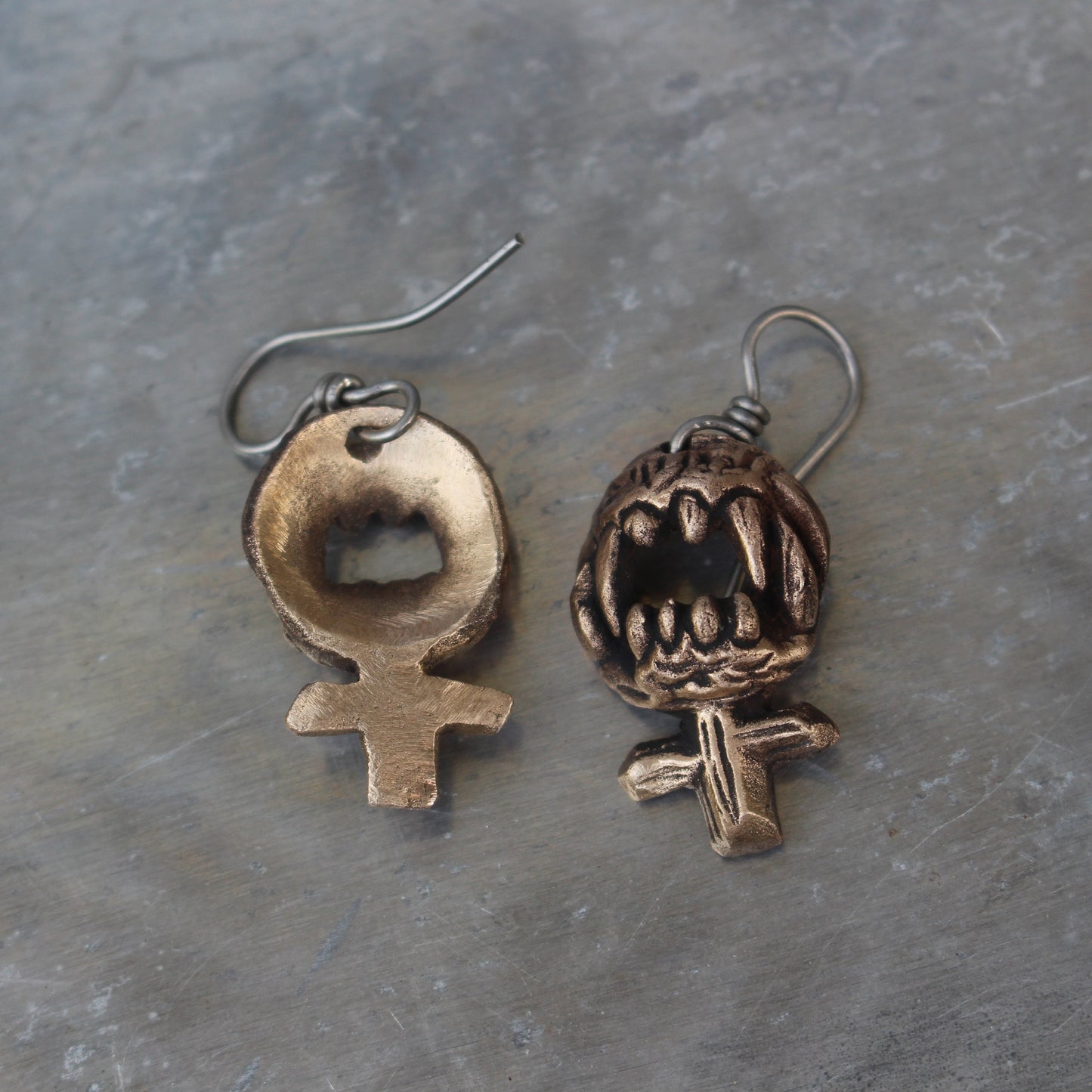 wild womman feminist sign earrings with sharp teeth ready to bite, handforged in bronze with titanium hooks